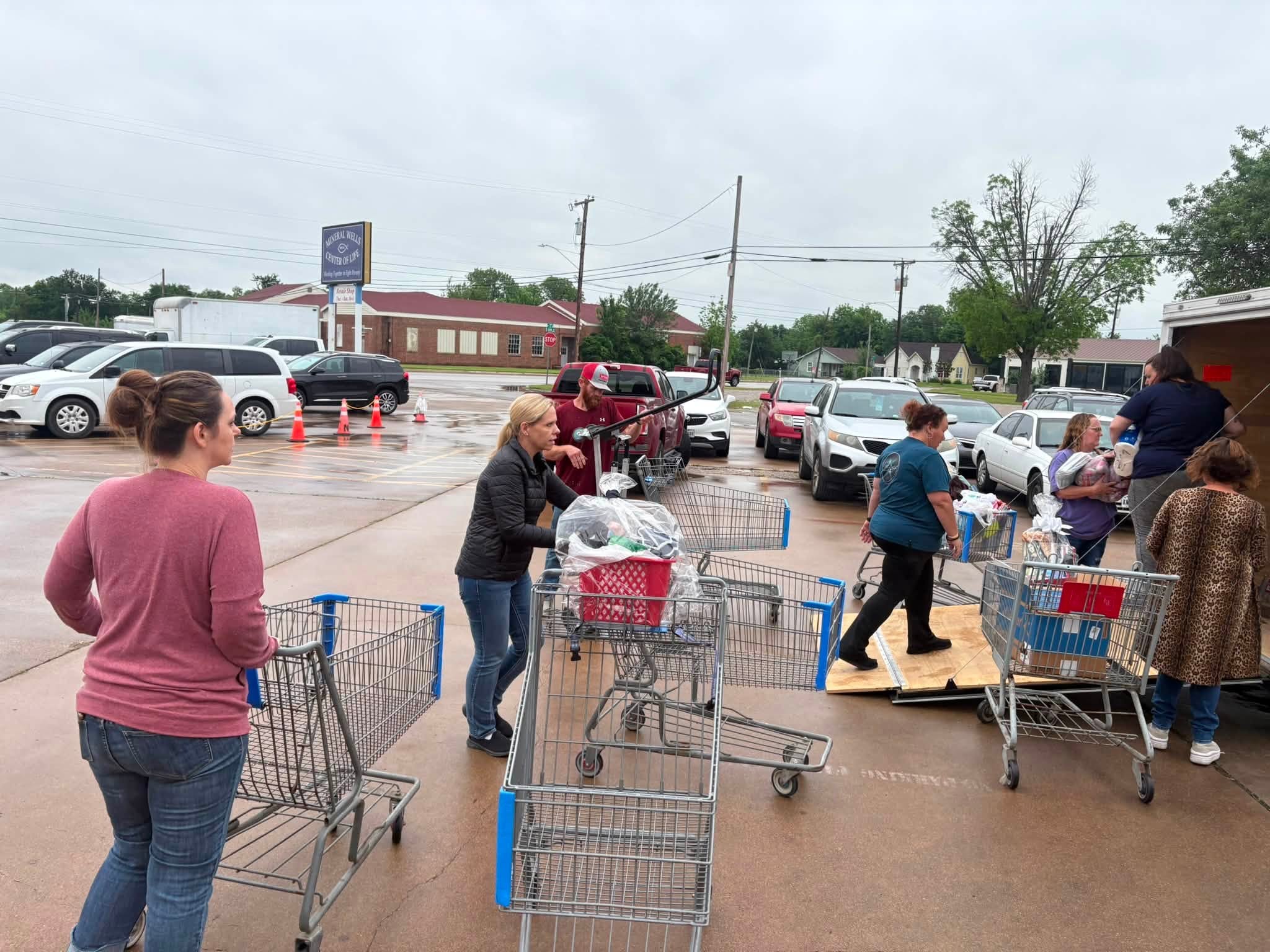 Helpers use carts to move relief supplies beside J-STAR's trailer at the Mineral Wells Center of Life.