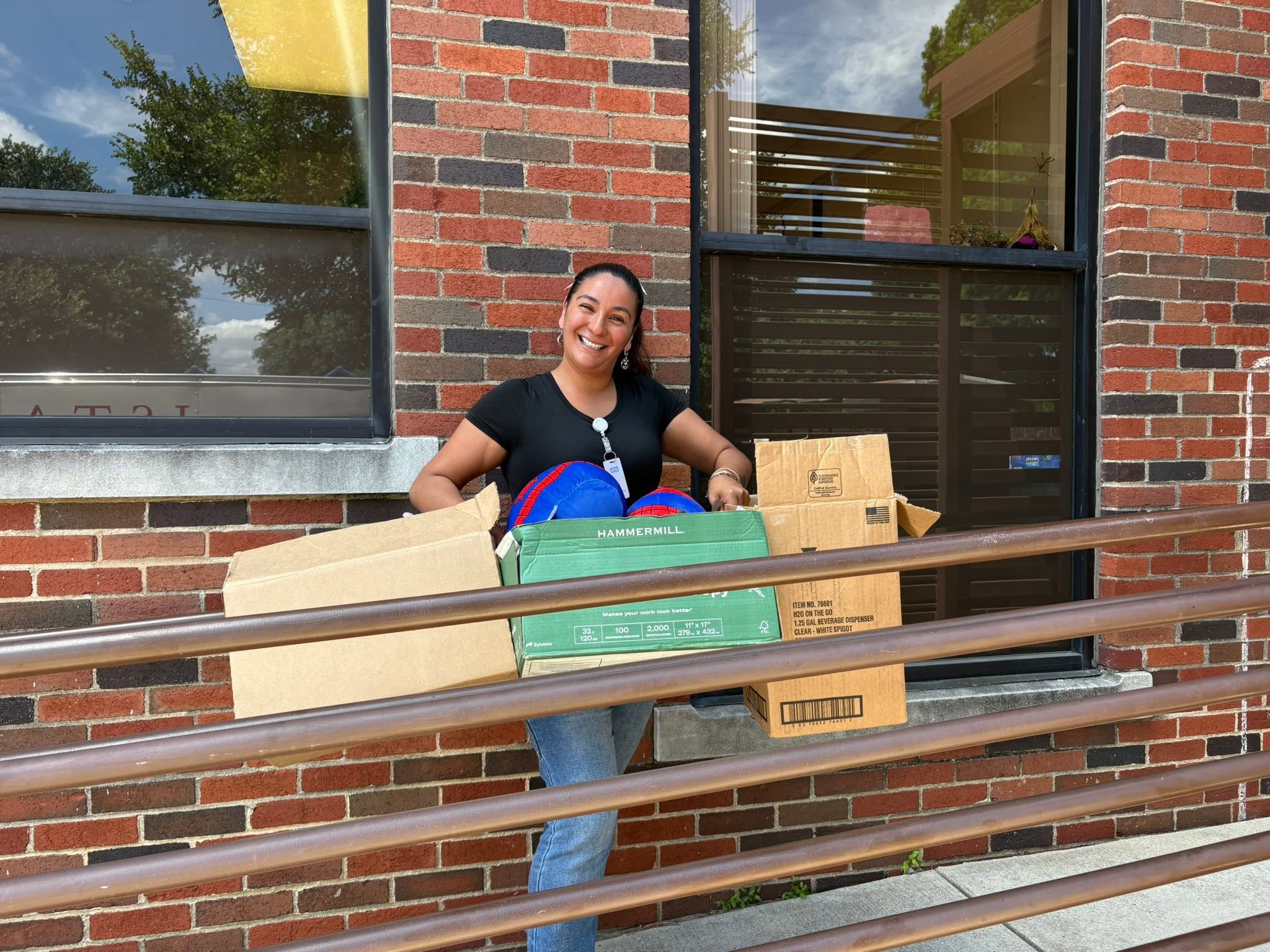 A Mission Oak Cliff partner carries donated backpacks and boxes of supplies.