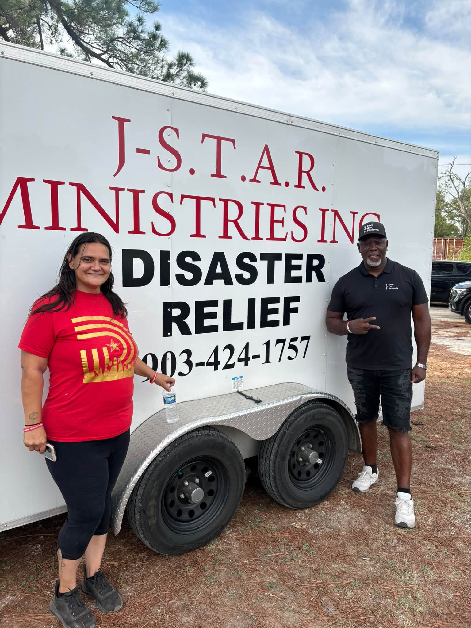 Patrick Johnson and a community partner beside the J-STAR disaster relief trailer in Sand Branch